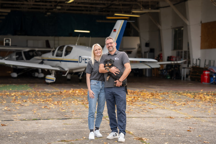 Gloria und Andreas vom Flugservice Bautzen GmbH vor der Flughalle – sympathisches Team mit Flugzeugen im Hintergrund, Rundflüge Bautzen